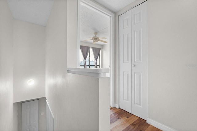 hallway with baseboards and wood finished floors