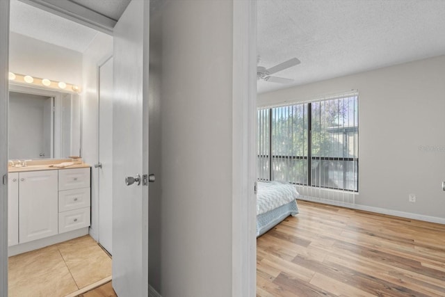 unfurnished bedroom featuring light wood finished floors, baseboards, and a textured ceiling