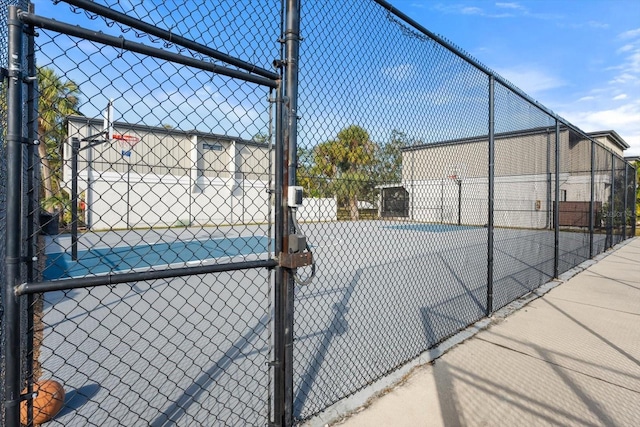 view of sport court featuring a gate, community basketball court, and fence