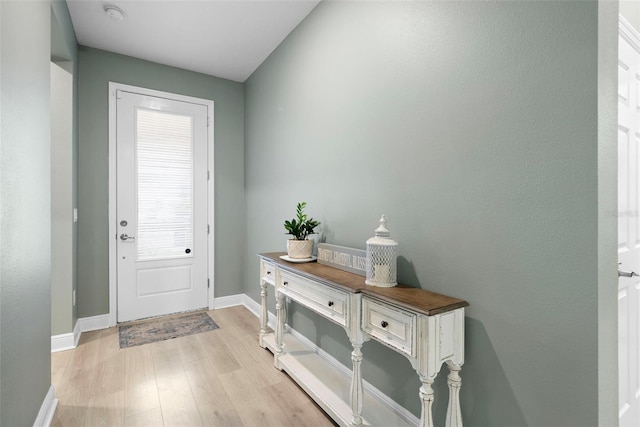 doorway with a wealth of natural light and light hardwood / wood-style flooring