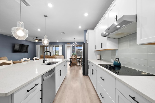 kitchen with sink, tasteful backsplash, black appliances, hanging light fixtures, and white cabinets