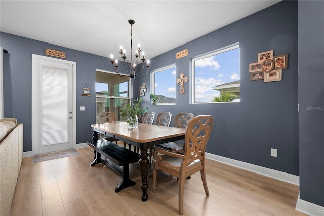 dining space featuring light wood-type flooring and an inviting chandelier