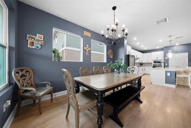 dining area with a chandelier and light hardwood / wood-style floors