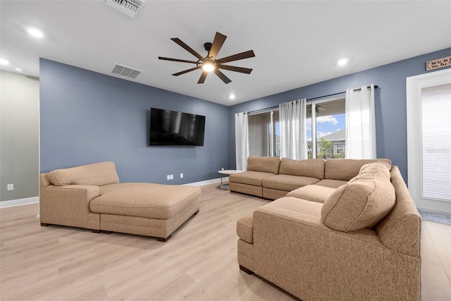 living room with light hardwood / wood-style flooring and ceiling fan