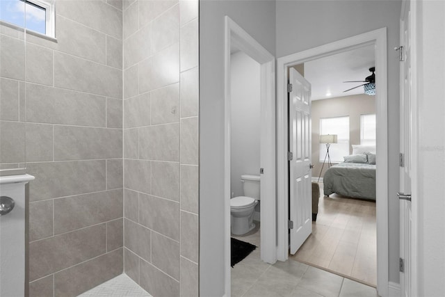 bathroom featuring ceiling fan, plenty of natural light, tile patterned floors, and toilet