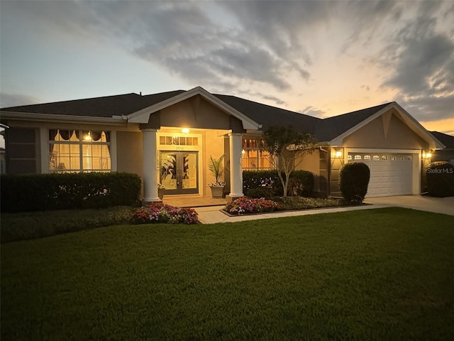 ranch-style house featuring a garage and a lawn