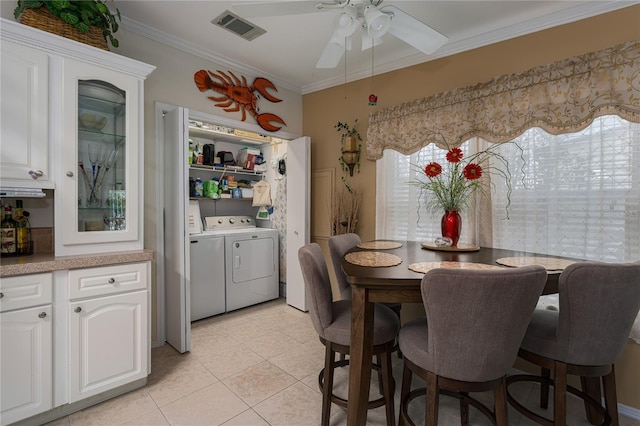 tiled dining room featuring ceiling fan, crown molding, and washing machine and clothes dryer