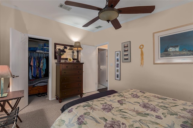 carpeted bedroom with ceiling fan, a closet, a walk in closet, and ornamental molding