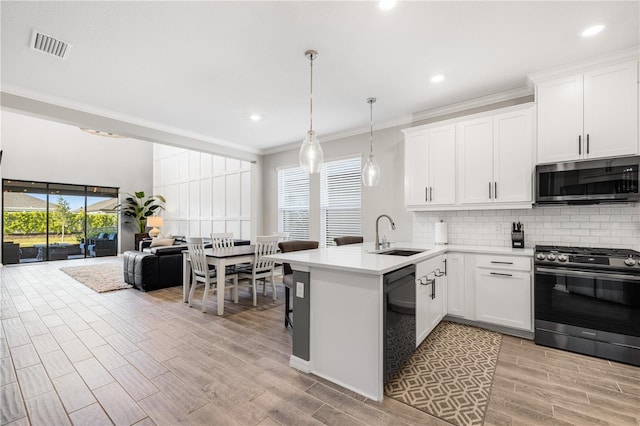 kitchen featuring pendant lighting, white cabinets, appliances with stainless steel finishes, sink, and kitchen peninsula