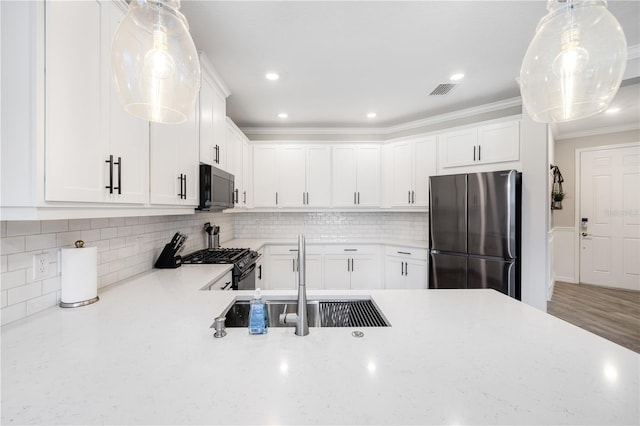 kitchen featuring white cabinetry, sink, hanging light fixtures, refrigerator, and gas range