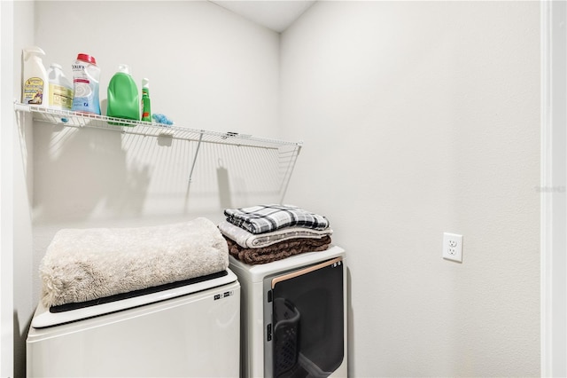 clothes washing area with washer and clothes dryer