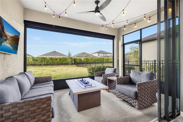 view of patio with ceiling fan and an outdoor living space with a fire pit