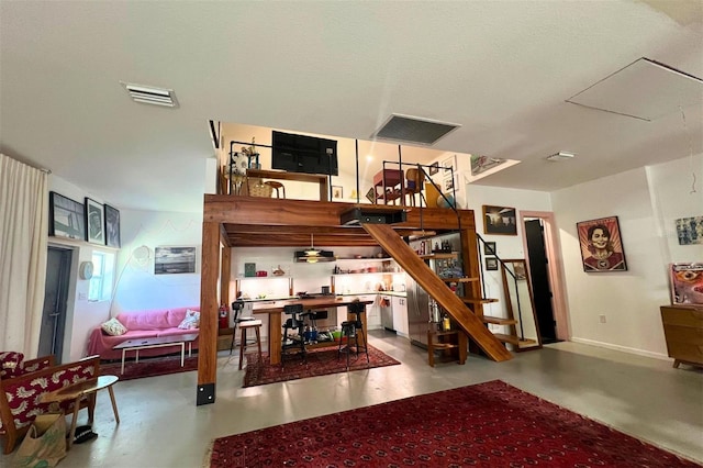 stairs featuring concrete flooring