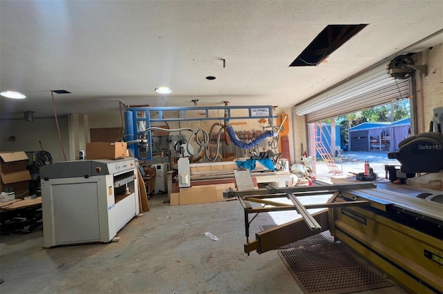 misc room with a workshop area, concrete floors, and a textured ceiling