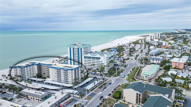 drone / aerial view featuring a water view, a beach view, and a city view