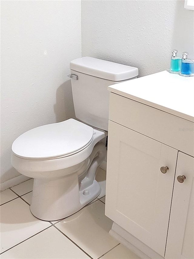 bathroom with toilet, tile patterned flooring, and vanity