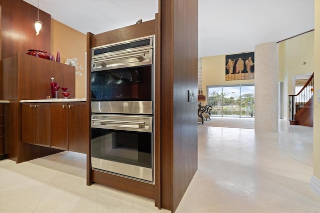 kitchen featuring hanging light fixtures, stainless steel double oven, and light tile patterned floors