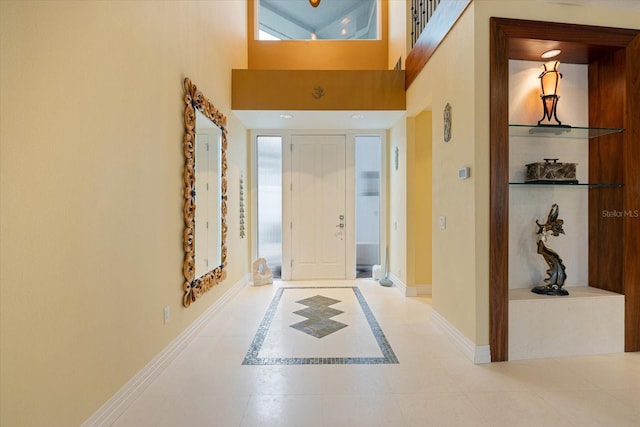 foyer entrance featuring light tile patterned floors and a high ceiling