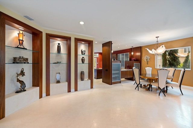 dining space featuring built in shelves and an inviting chandelier