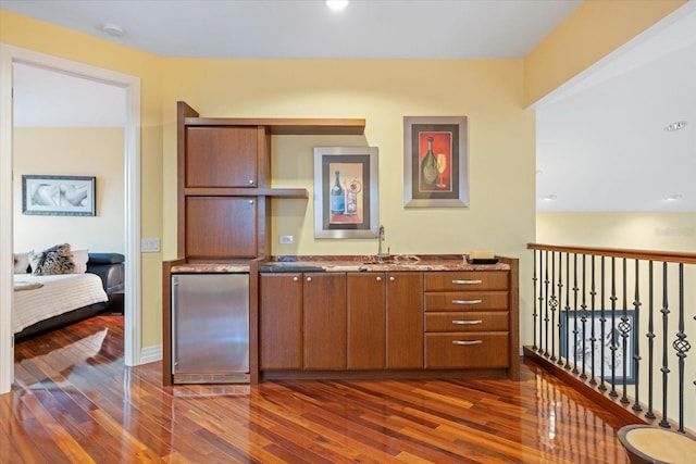 kitchen with sink, dark hardwood / wood-style flooring, and stainless steel refrigerator