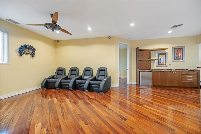 cinema featuring ceiling fan, dark wood-type flooring, and sink