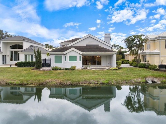 back of property featuring a yard, a water view, and central air condition unit