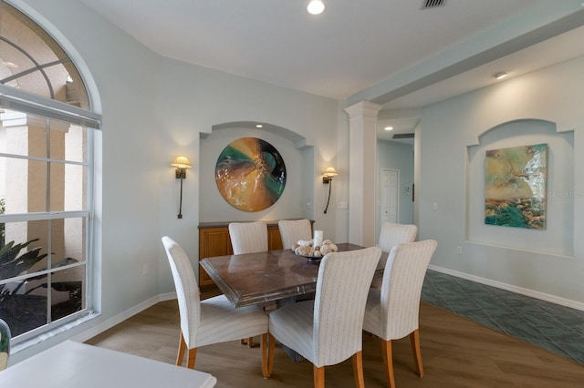 dining area featuring decorative columns and hardwood / wood-style floors