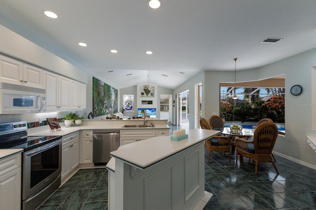 kitchen featuring appliances with stainless steel finishes, decorative light fixtures, white cabinetry, sink, and a notable chandelier