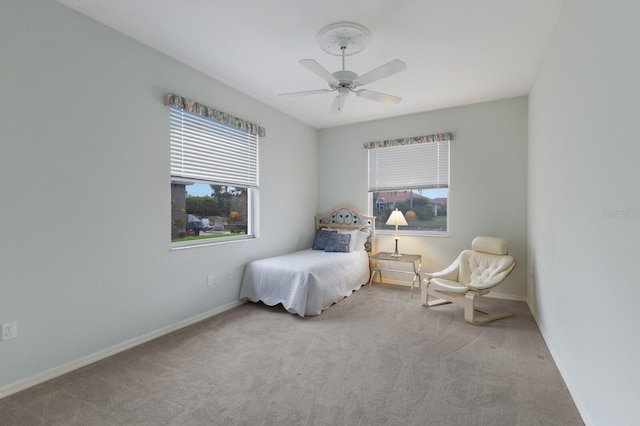 bedroom with ceiling fan, multiple windows, and light carpet