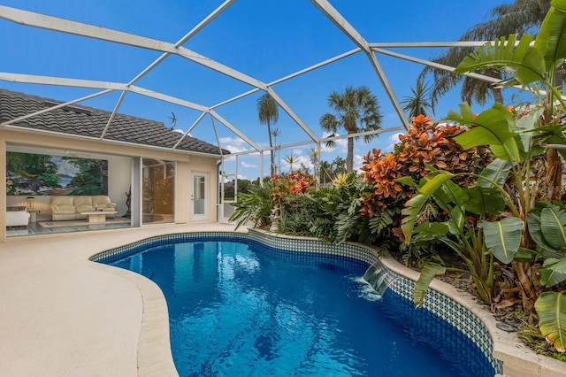 view of pool with glass enclosure, a patio area, an outdoor living space, and pool water feature