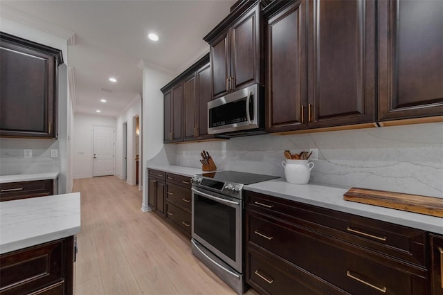 kitchen featuring appliances with stainless steel finishes, ornamental molding, dark brown cabinetry, light hardwood / wood-style flooring, and backsplash