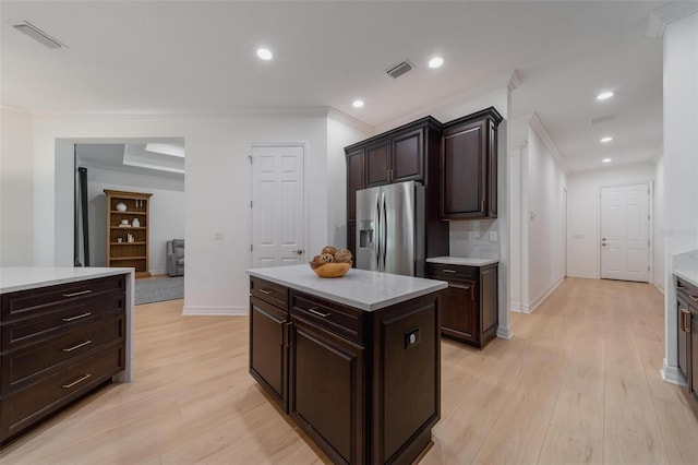 kitchen with dark brown cabinetry, ornamental molding, stainless steel refrigerator with ice dispenser, and a center island