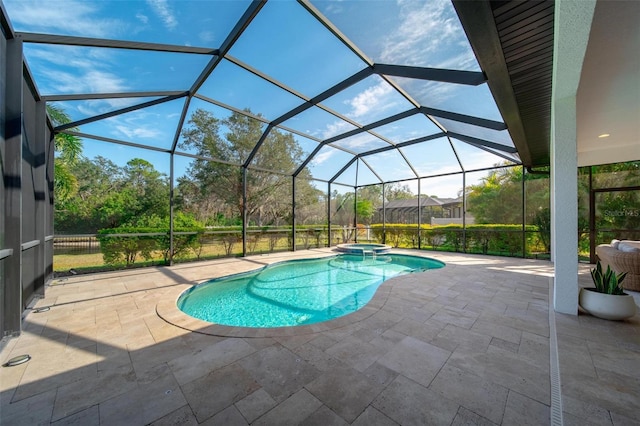 view of pool featuring a patio, glass enclosure, and an in ground hot tub