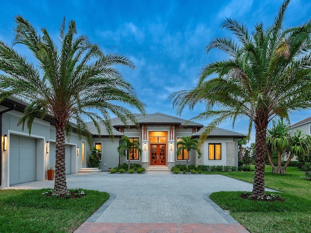 view of front of home with a garage, a front lawn, and french doors