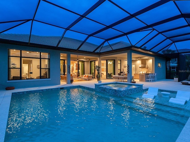 view of swimming pool with an in ground hot tub, an outdoor kitchen, a patio area, and glass enclosure