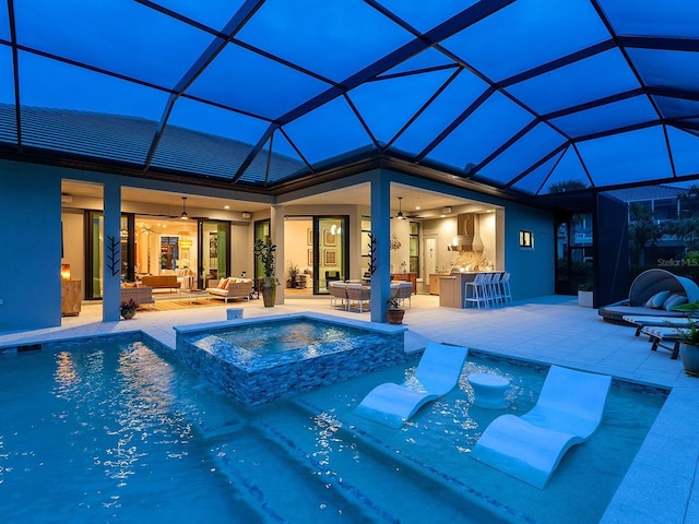 view of pool with ceiling fan, a patio, glass enclosure, an outdoor hangout area, and an in ground hot tub