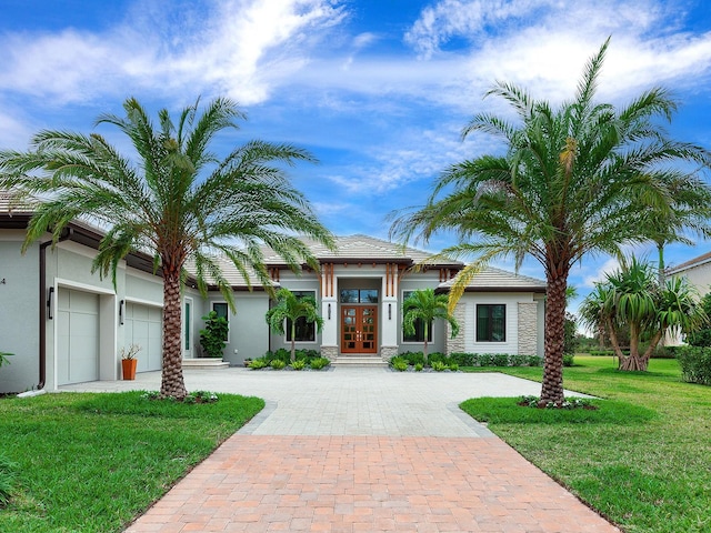 view of front of home with a garage, a front lawn, and french doors