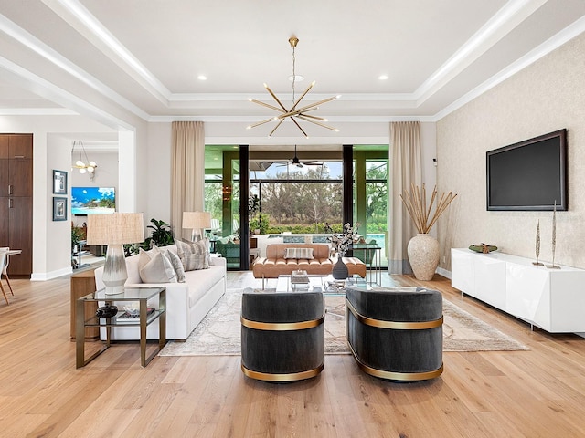 living room featuring a notable chandelier, crown molding, light hardwood / wood-style flooring, and a raised ceiling