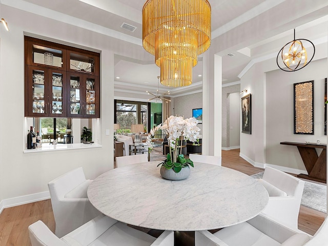 dining area featuring a notable chandelier, crown molding, and light wood-type flooring