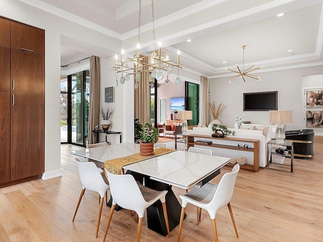 dining space featuring ornamental molding, a tray ceiling, light hardwood / wood-style flooring, and a notable chandelier