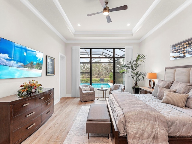 bedroom featuring a raised ceiling, ornamental molding, access to exterior, and light hardwood / wood-style floors