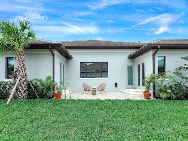 rear view of house featuring a patio and a lawn