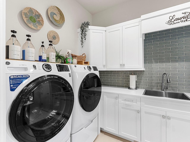 laundry room featuring cabinets, separate washer and dryer, and sink