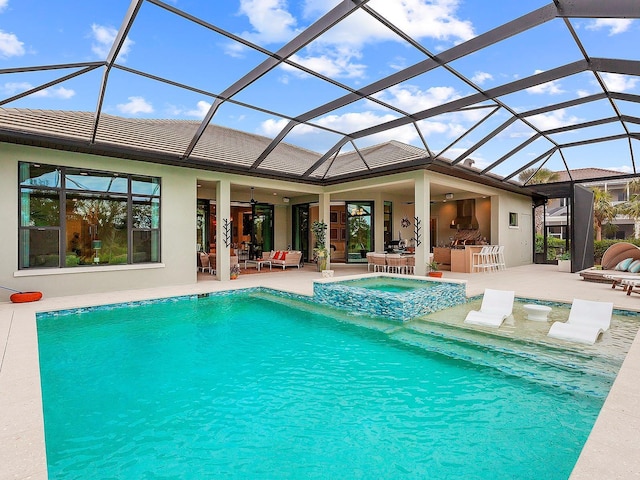 view of pool featuring a patio area, a lanai, an in ground hot tub, ceiling fan, and exterior bar