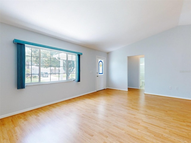 unfurnished room with vaulted ceiling and light hardwood / wood-style flooring