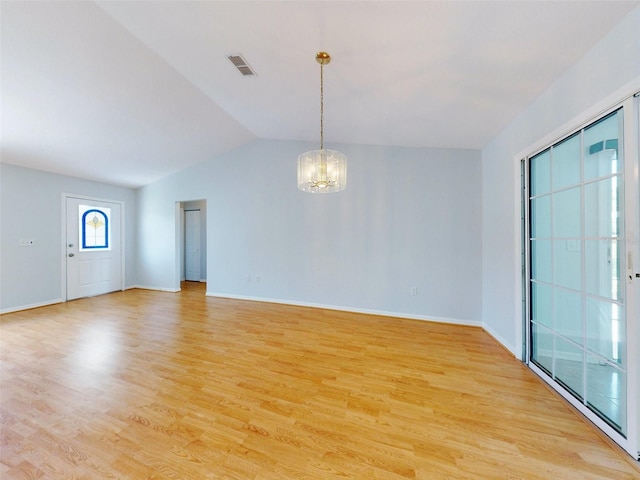 entryway featuring light hardwood / wood-style flooring, vaulted ceiling, and a chandelier