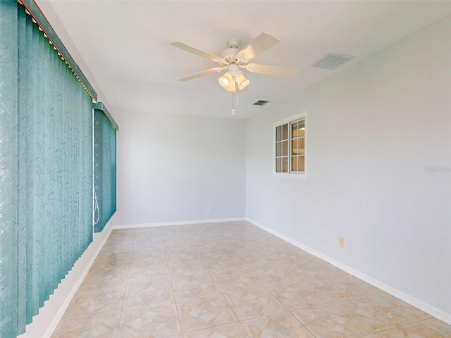 tiled spare room featuring ceiling fan