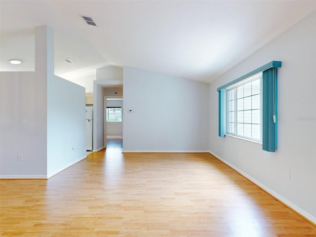 unfurnished room with light hardwood / wood-style flooring and vaulted ceiling