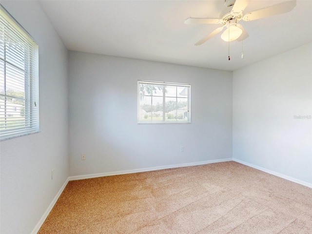 unfurnished room featuring ceiling fan, light carpet, and a healthy amount of sunlight