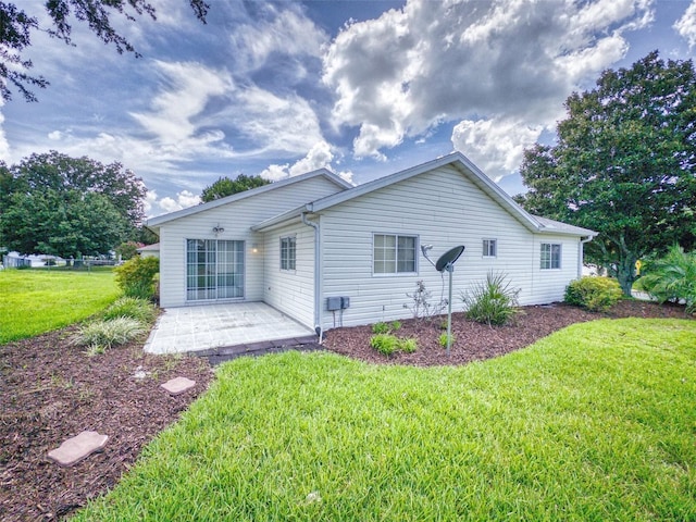 back of property featuring a patio and a yard